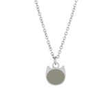 A silver chain necklace with a minimalist pendant shaped like a cat head, featuring a solid sage green circular face, shown against a plain white background.