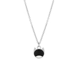 A silver chain necklace with a pendant shaped like a cat face, featuring a black enamel fill on the upper half and a silver outline on the lower half, shown against a plain white background.