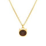 A gold chain necklace with a small cat-shaped pendant featuring a dark brown face with white eyes and mouth, shown against a plain white background.