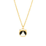 A gold chain necklace featuring a small pendant shaped like a cat face, with black and white enamel details, shown against a plain white background.