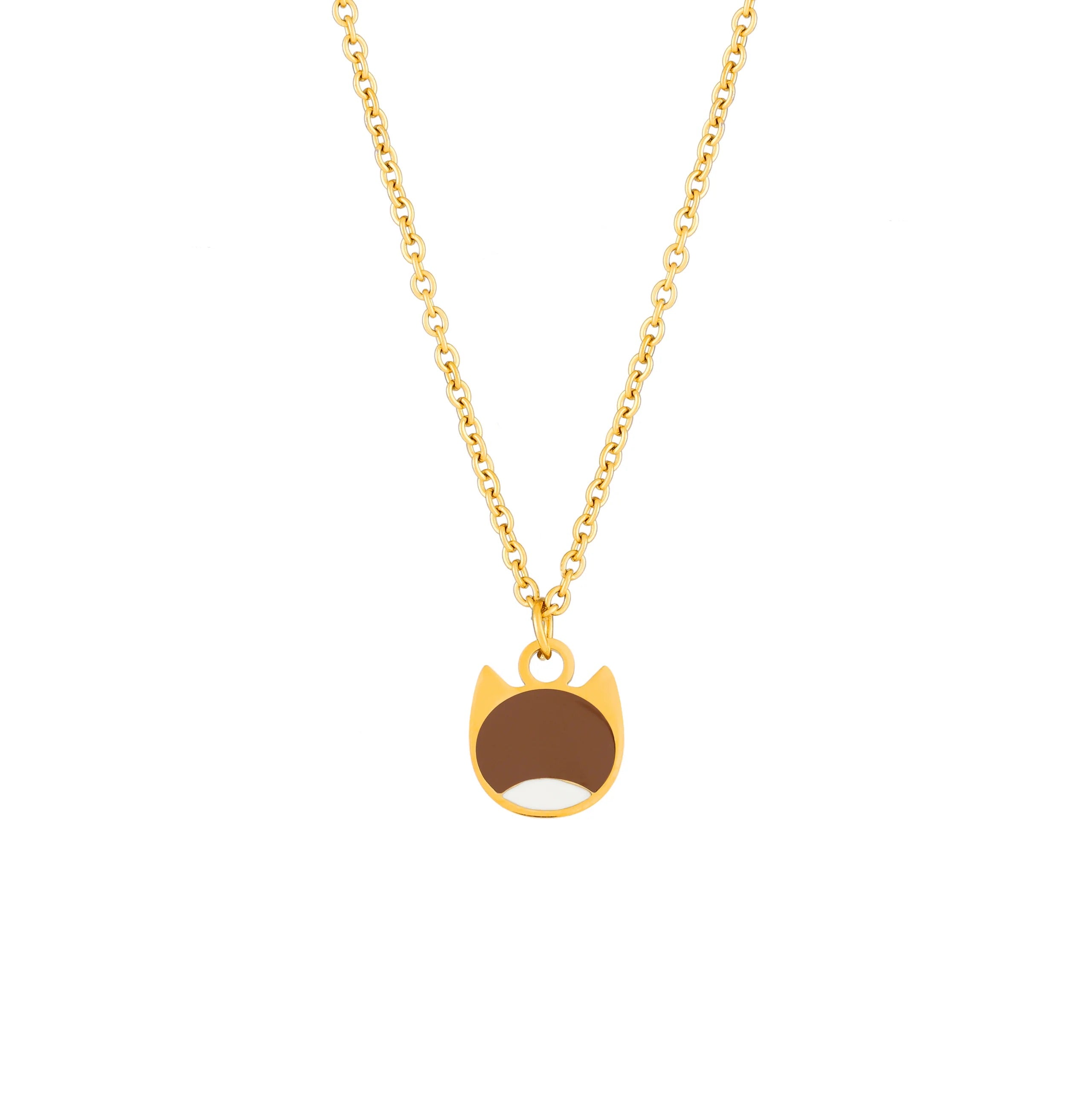 A gold chain necklace with a small pendant shaped like a cat face, featuring a brown center and white lower half, shown on a plain white background.