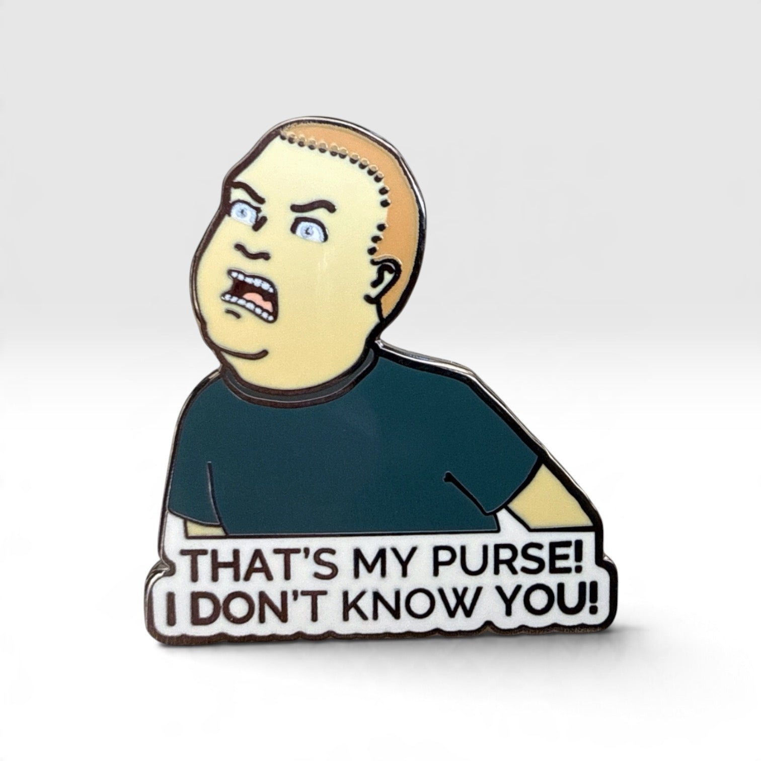 An enamel pin featuring a cartoon character with a surprised face and the text 'THAT'S MY PURSE! I DON'T KNOW YOU!' on a light gray background.
