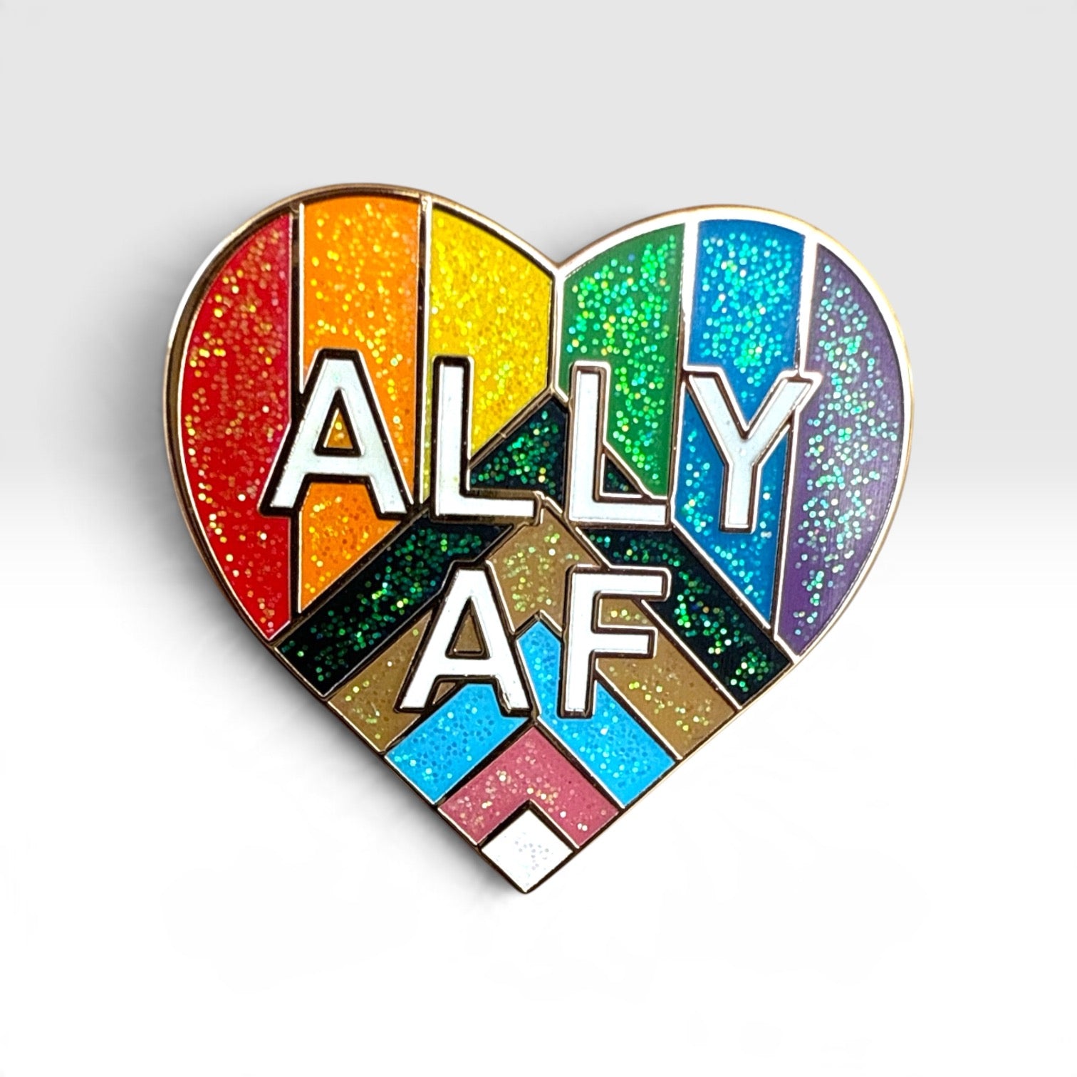 A heart-shaped enamel pin featuring a rainbow-striped design with glitter texture and the text 'ALLY AF' in white letters with black outlines, set against a light gray background.