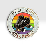 A circular enamel pin featuring roller skates over a retro rainbow background with the words 'ROLL LOUD' at the top and 'ROLL PROUD' at the bottom, shown on a light gray gradient background.