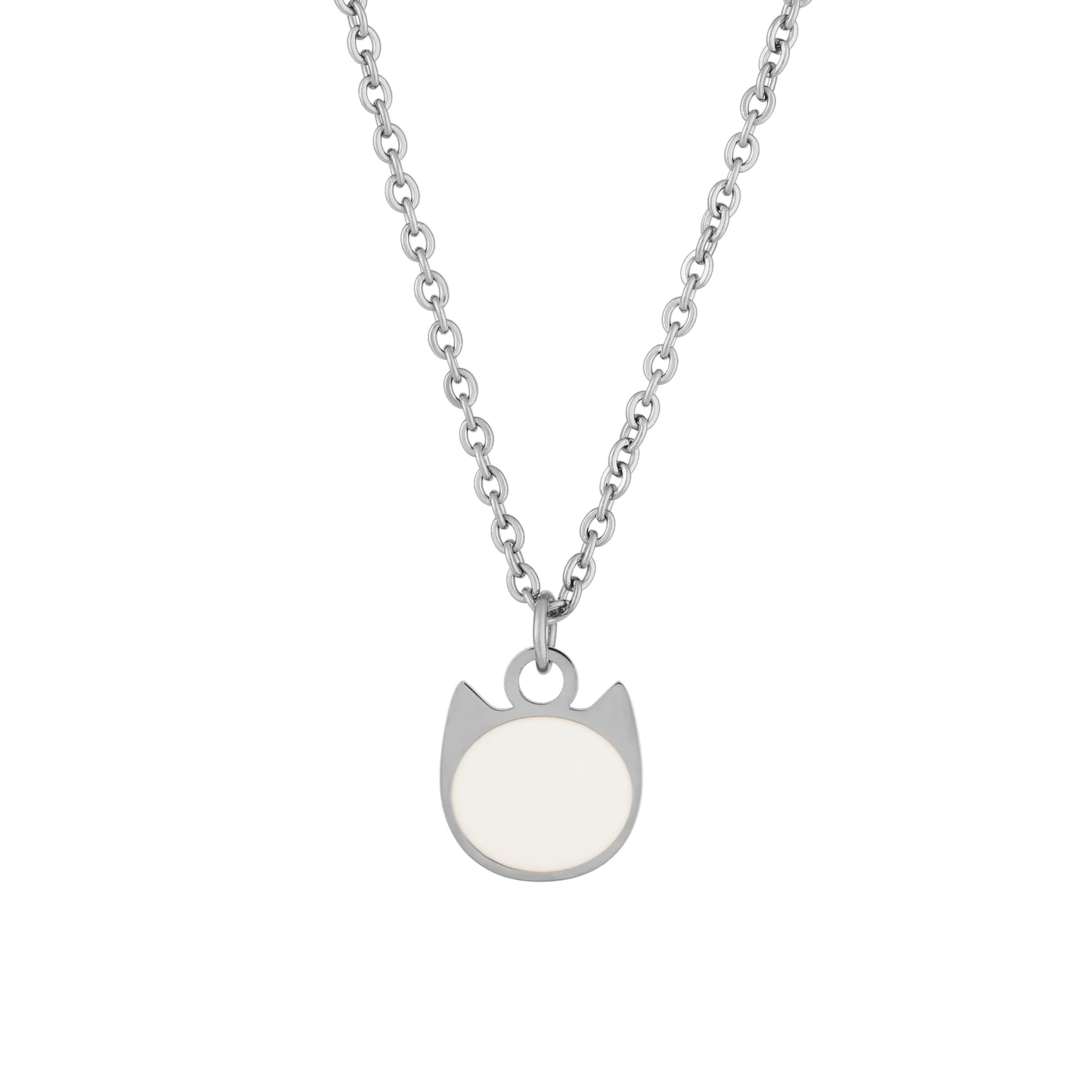 A silver-toned necklace featuring a minimalist pendant shaped like a cat's head with a smooth, circular off-white face, displayed against a solid white background.