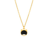 A gold chain necklace with a cat-face pendant featuring a black enamel center and white enamel lower half, shown on a plain white background.