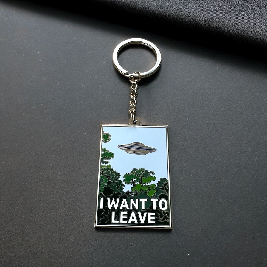 I Want to Leave enamel keychain with a UFO and treeline design in silver plate